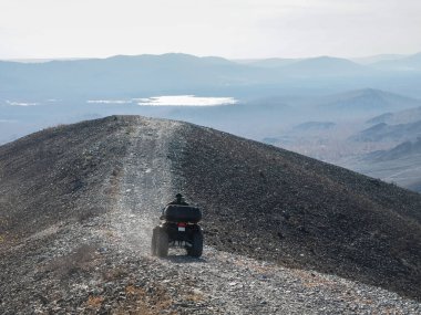 Dağ yolunda dört tekerli motosiklet kullanan yarışçıların hava manzarası. Vahşi bir yolda dört tekerli bisiklet. ATV. Arkadan bak. Rusya, Karabaş, Chelyabinsk bölgesi