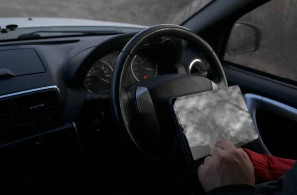 driver of the car with a tablet computer as a car Navigator. Mockup. no face.