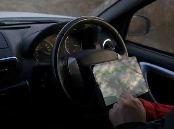 driver of the car with a tablet computer as a car Navigator. Mockup. no face.