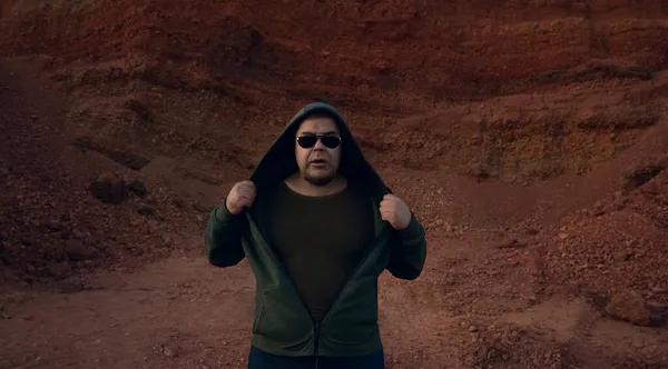 Young man in sunglasses standing on mountain