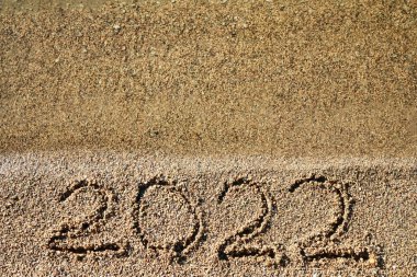 2022 yeni yıl konsepti. Sahil şeridindeki kumlara su ile yazılmış 2022 sayısının en üst görünümü. 