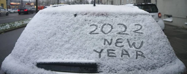 車のバックウィンドウで番号が2022年に書かれている白い車の雪 2022年あけましておめでとうございます ドイツ ミュンヘン — ストック写真