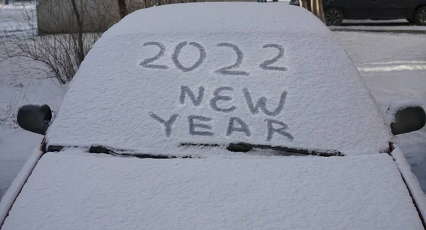 2022年新年快乐 挡风玻璃雨刷和一辆被雪覆盖的汽车 — 图库照片