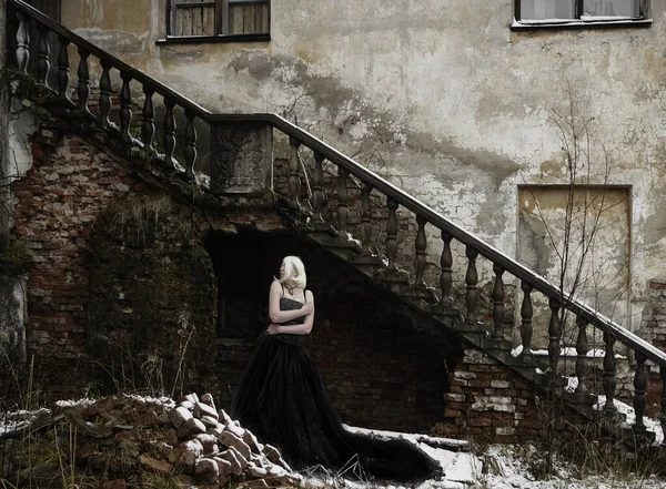 美丽的年轻而纤细的高加索女子站在废弃的旧城墙篱笆旁边的画像 — 图库照片