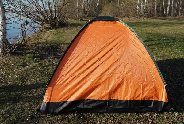 背景の青い湖の近くのオレンジのテント 春のキャンプ — ストック写真