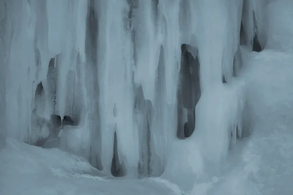 A frozen waterfall with ice in winter. Winter background.