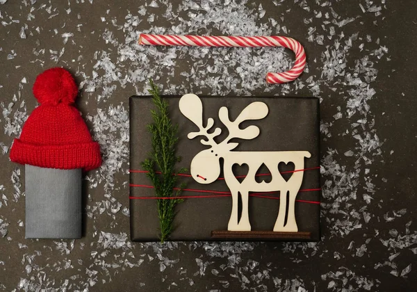 黑色背景的圣诞礼物 圣诞礼品盒 糖果手杖 手套在黑桌上 顶部视图与空间您的问候 木制鹿形标志 — 图库照片