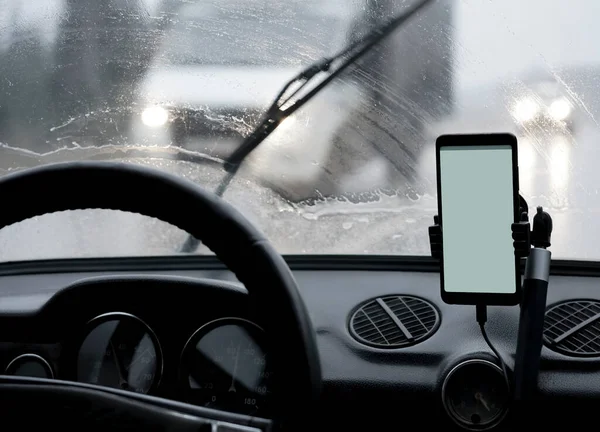 smartphone white blank screen inside the car. Mock up image.  blank colorful screen mobile smart phone inside a car in rainy day