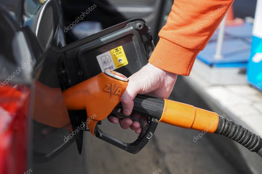 MOSCOW, RUSSIA - JUNE 05, 2021: Gasoline ZVA station filled up E95. Refuel cars at the fuel pump. driver hands, refuel and pump the car's gasoline with fuel at the petrol station. Car refueling