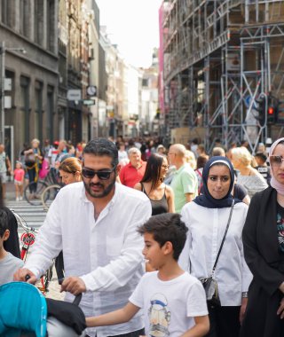 Amsterdam, Hollanda - 22 Temmuz 2018: büyük Arap ya da Asyalı aile çocuklarını bebek arabalarıyla dolaştırıyor. Arap gençleri tesettür giyer.