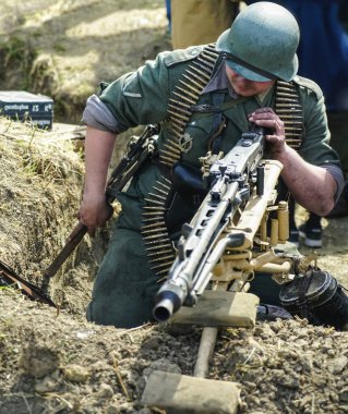 İkinci Dünya Savaşı sırasında askerlerin tarihi yeniden canlandırması. Yüzü yok. Alman askerleri. Yeniden yapılanma, 2. Dünya Savaşı sırasında savaşan askerler. makineli tüfekçi