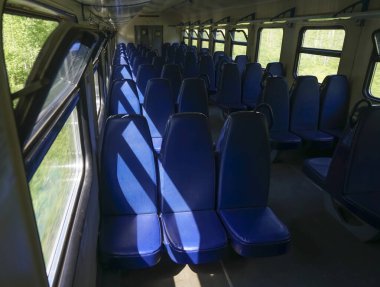 Banliyö treninde boş mavi koltuklar. Rusya 'da boş elektrikli tren vagonu. Yaz günü bir banliyö elektrikli treninin içinde.