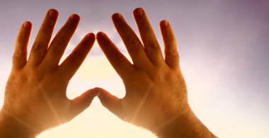 Kalp sembolü gökyüzü arka planındaki eller, Aşk ya da Sağlık kavramı. Kavramsal insan, erkek ya da kadın, birbirine aşık, sevgililer günü şekli ya da mavi gökyüzü arka planındaki kalp sembolü.