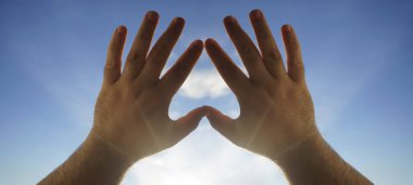 Kalp sembolü gökyüzü arka planındaki eller, Aşk ya da Sağlık kavramı. Kavramsal insan, erkek ya da kadın, birbirine aşık, sevgililer günü şekli ya da mavi gökyüzü arka planındaki kalp sembolü.