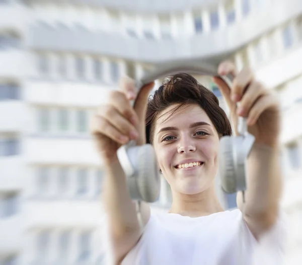 Chica Feliz Sosteniendo Grandes Auriculares Blancos Sonriendo Sobre Fondo Blanco — Foto de Stock