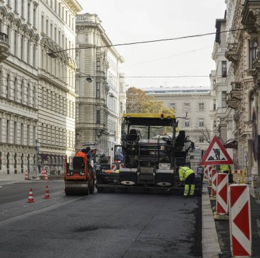İnşaat alanı yeni asfalt yol kaldırımları, yol inşaat işçileri ve yol yapım makineleri sahnesi inşa ediyor. İnşaat alanı manzarası. VIENNA, AUSTRIA