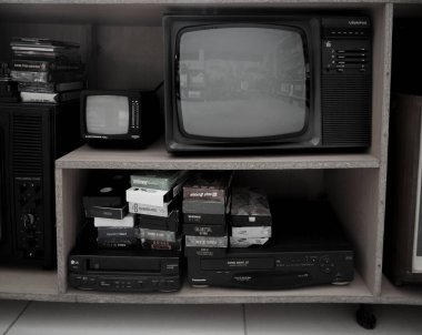 Eski video kaydedici ve televizyon. Rafta klasik Video VHS Oynatıcı var. VHS kasetleri ve DVD diskleri.