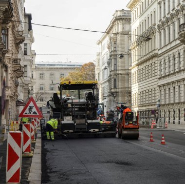 VIENNA, AUSTRIA - NOVEMBER 07, 2017: İnşaat alanı yeni asfalt yol kaldırımı, yol yapım işçileri ve yol yapım makineleri sahnesi seriyor. İnşaat alanı manzarası.