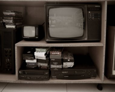 Eski video kaydedici ve televizyon. Rafta klasik Video VHS Oynatıcı var. VHS kasetleri ve DVD diskleri.