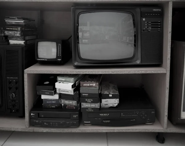 旧录像机和电视机 古董视频Vhs播放器在货架上 Vhs盒式磁带和Dvd光盘 — 图库照片