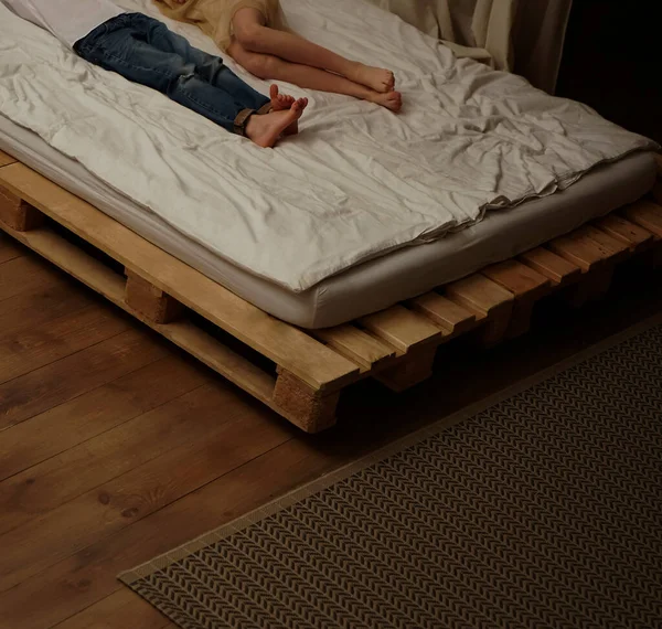躺在床上盖着毯子的人 脚的近视 — 图库照片