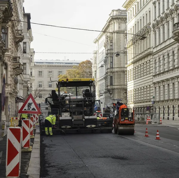 VIENNA, AUSTRIA - NOVEMBER 07, 2017: İnşaat alanı yeni asfalt yol kaldırımı, yol yapım işçileri ve yol yapım makineleri sahnesi seriyor. İnşaat alanı manzarası.