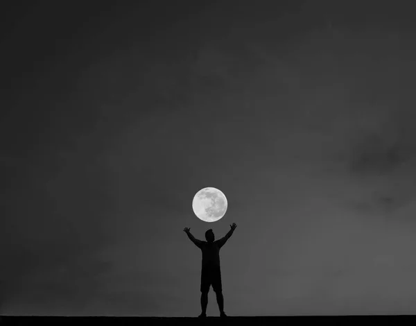 夜を背景に手を上げて若い男のシルエット 夜のシーン — ストック写真