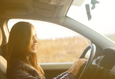 Modern arabanın içinde oturan güzel esmer kadın. İspanyol kız direksiyonun arkasındaki koltukta oturuyor.