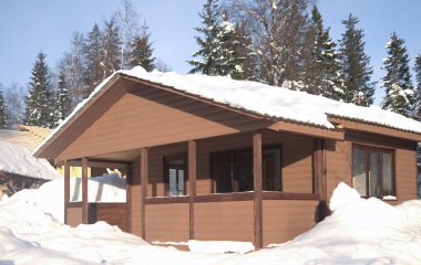 Kış dağlarında bir şato, karda bir kulübe. Kış dağı manzarası. Güney Ural, Rusya. Ahşap ev, soğuk bir kış gününde dağlarda dağ evi.