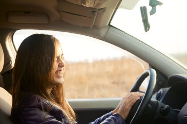 Modern arabanın içinde oturan güzel esmer kadın. İspanyol kız direksiyonun arkasındaki koltukta oturuyor.