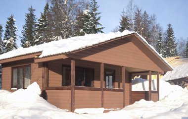 Kış dağlarında bir şato, karda bir kulübe. Kış dağı manzarası. Güney Ural, Rusya. Ahşap ev, soğuk bir kış gününde dağlarda dağ evi.