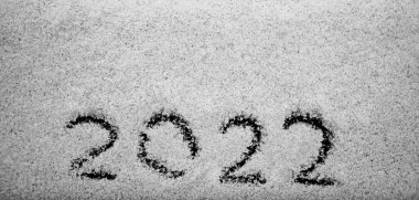 Güneş ışığında beyaz kar çiziyor. Yeni yıl tarihi, 2022 rakamları, yakın plan. Kış tatili, Noel, yeni yıl konsepti. boş kopyalama alanı.