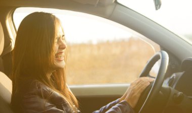 Modern arabanın içinde oturan güzel esmer kadın. İspanyol kız direksiyonun arkasındaki koltukta oturuyor.