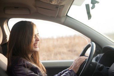 Modern arabanın içinde oturan güzel esmer kadın. İspanyol kız direksiyonun arkasındaki koltukta oturuyor.