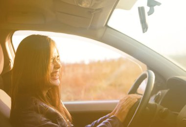 Modern arabanın içinde oturan güzel esmer kadın. İspanyol kız direksiyonun arkasındaki koltukta oturuyor.