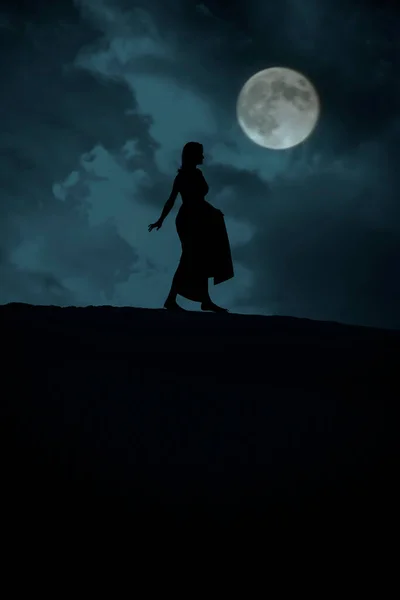 Sylwetka Kobiety Chodzącej Pełnią Księżyca Niebieskim Tle Zachmurzone Niebo — Zdjęcie stockowe