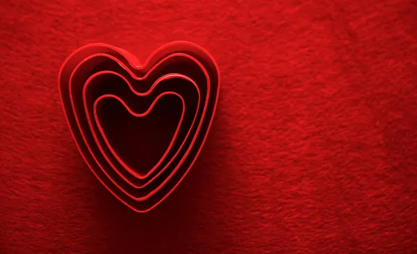 Fondo Material Rojo Con Muchas Formas Símbolos Del Corazón Febrero — Foto de Stock