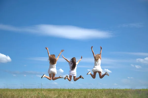 여성이 하늘을 배경으로 점프하는 장면이 보입니다 여름의 들판과 풀들이 있노라 — 스톡 사진
