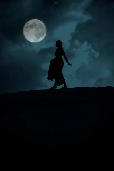 Sylwetka Kobiety Chodzącej Pełnią Księżyca Niebieskim Tle Zachmurzone Niebo — Zdjęcie stockowe