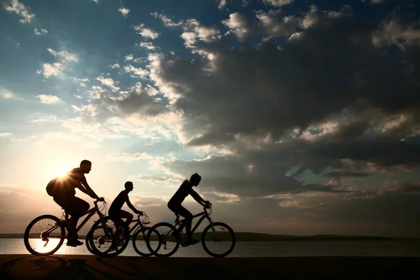 Boşluk Gün Batımında Bisiklete Binen Sportif Arkadaşlar Bisikletçiler Sahil Boyunca — Stok fotoğraf