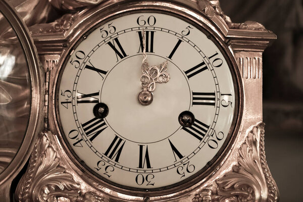 ancient golden watch with  cover and pattern. clock dial with hands. one o'clock in the afternoon. one o'clock in the morning