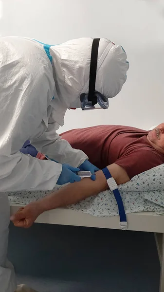 在Covid 19疫苗接种活动期间 一名护士向卧床病人的右肩注射疫苗 针头和注射器男病人躺在病床上 治疗概念 老年人康复 — 图库照片