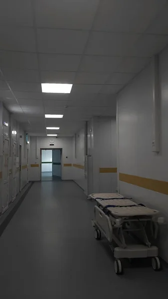 現代病院の医療ベッドと長い廊下 多くのコピースペースを持つ病院の内部 レセプションで様々な部屋やトロリーの患者サービスと空の病院の廊下のインテリア — ストック写真