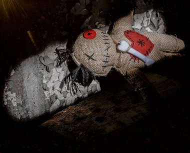 Tatlı cadılar bayramı gülümseyen kahverengi voodoo bebeği kırmızı kalbi ve kemikleri siyah duvar arkasında izole