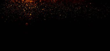 Siyah arka planda altın parıldayan sihirli altın tozu. Koyu arkaplan üzerindeki parçacıklar