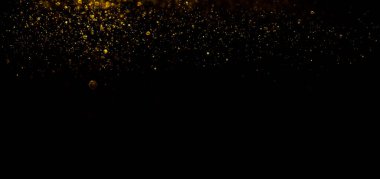 Siyah arka planda altın parıldayan sihirli altın tozu. Koyu arkaplan üzerindeki parçacıklar
