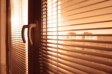 Jaluzi ile pencereyi kapattım, yazın jaluzi yapıyorum. Pencere çerçevesi, güneş ışınları ve parlak güneş ışığı. Oturma odası. boş kopyalama alanı.