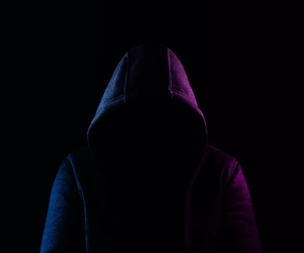 empty Hoodie isolated on black background.  violet and blue light low key image. unrecognizable person. mock up image.