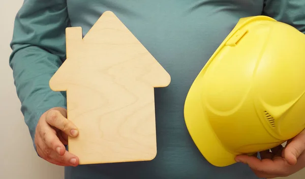 Bauarbeiter Mit Gelbem Helm Und Hölzernem Hausschild Der Hand Isoliert — Stockfoto