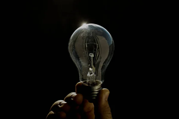 Hand Med Glödlampa Isolerad Svart Bakgrund — Stockfoto